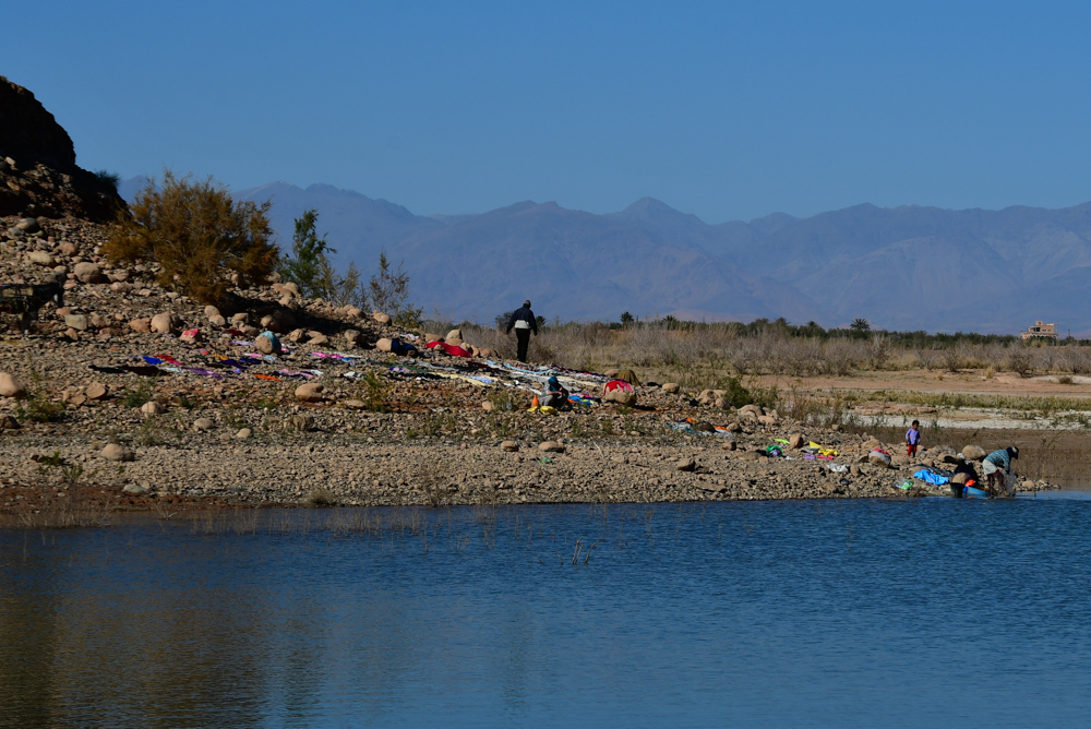 Familie waescht Kleider am Stausee bei Ouarzazate